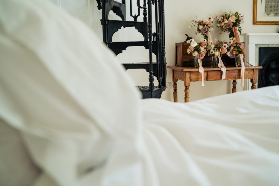 Bridal bouquets on a table in a bedroom. Wedding flowers with ribbons. Black spiral staircase.